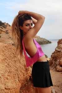 Détail du top dos nu rose vif en maille métallique à paillettes avec une coupe sexy chic