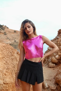 Détails de la maille métallique rose brillant et de la jupe plissée noire tendance