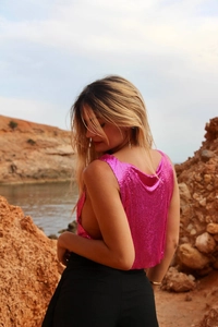 Détail du haut en maille métallique rose vif à dos nu avec une texture de sequins