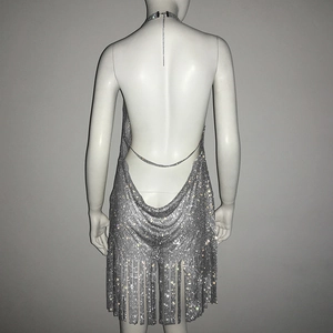 Détail de robe en maille strass argentée avec dos nu à chaîne et ourlet à franges