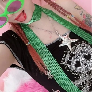 Close-up of Y2K silver star necklace and neon green mesh scarf on a model
