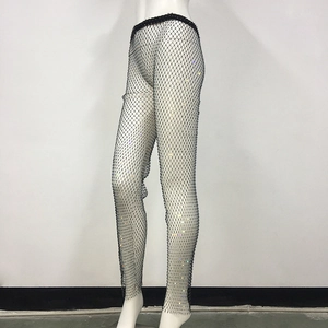 Dettaglio dei pantaloni a rete neri con strass colorati scintillanti ad effetto luce
