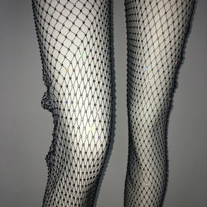 Dettaglio di calze a rete nere con strass colorati scintillanti e trama in rete elastica