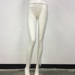 Dettaglio dei pantaloni a rete bianchi con strass brillanti e vita alta sexy
