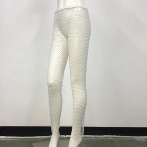 Dettaglio dei pantaloni a rete bianchi con strass scintillanti ed elastico in vita