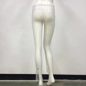 Dettaglio dei pantaloni a rete bianchi con strass scintillanti e tessuto a rete elasticizzato