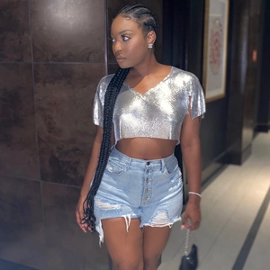 Dettaglio del crop top in paillettes metalliche argentate con scollo a V per festival