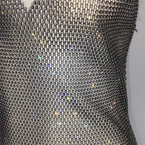 Close-up of black mesh fabric with dense glittering rhinestones for sexy party dress