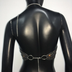 Dettaglio di anelli metallici e catene sul retro della catena per il corpo con strass