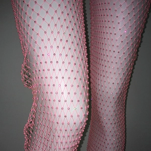 Dettaglio di pantaloni in rete rosa con strass su un manichino per un effetto scintillante