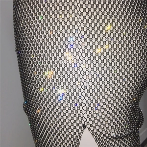 Close-up of sparkling rhinestones on black mesh fabric for a sexy party dress