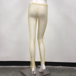 Dettaglio dei pantaloni a rete dorata con strass brillanti e trama del tessuto