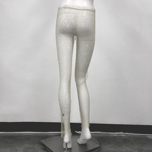 Dettaglio ravvicinato dei pantaloni a rete con strass argentati e finitura scintillante