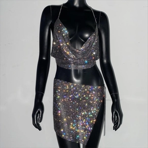 Dettaglio di strass colorati scintillanti su un completo due pezzi da festa in rete nera