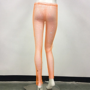 Vista dettagliata dei pantaloni a rete arancioni con strass scintillanti e design a rete