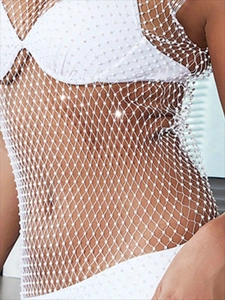 Détail de la robe en maille blanche ornée de strass scintillants sur un filet en losange