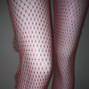 Dettaglio di collant a rete rosa con strass scintillanti e trama a rombi elastica
