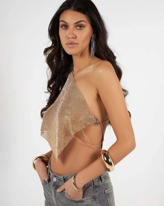 Close-up of golden metal mesh vest with sparkling rhinestones and chain link straps