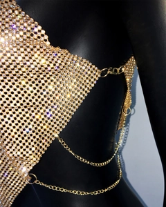 Macro view of lobster clasp and tiered gold chains on rhinestone metal mesh top