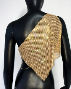 Detail of gold rhinestone mesh one-shoulder top with metallic side chain adjustment