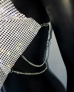 Detail view of sparkling rhinestone mesh top with silver metal chain on black mannequin