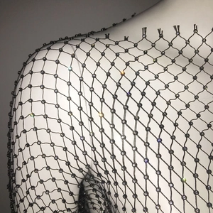 Detail of black mesh top with shimmering rhinestones on a diamond knit pattern