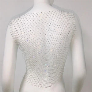 Close-up of shimmering rhinestone fishnet top with silver mesh and glitter details
