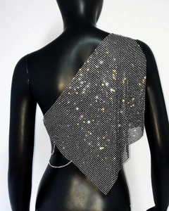 Detailed view of silver rhinestones and metal chain on asymmetrical crop top