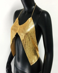 Détail d'un haut dos nu à paillettes dorées avec bretelles chaîne et mesh