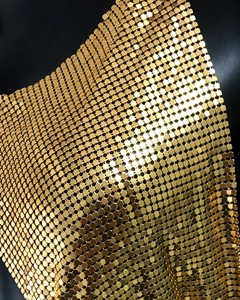 Gros plan sur le tissu en maille de paillettes métalliques dorées aux pièces carrées