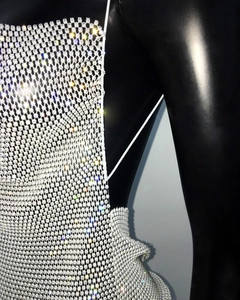 Close-up of sparkling silver rhinestone mesh and delicate chain straps on the dress