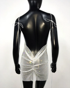 Detail of silver sequin mini dress featuring backless design and adjustable tie straps