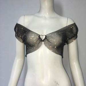 Detalle de top corto de malla negra con pedrería y hebilla de corazón plateada frontal
