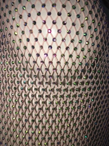 Dettaglio dell'abito a rete rosa con strass scintillanti su tessuto a rombi