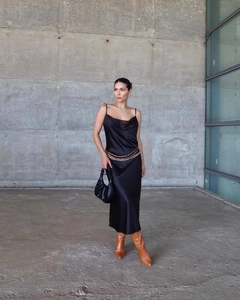 Détail d'une robe nuisette en satin noir avec col bénitier et chaîne de taille dorée