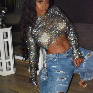 Détail du haut court en maille noire pour femme avec strass brillants et manches longues