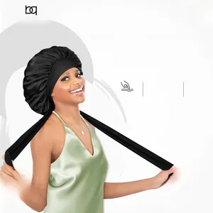 Detail of black satin bonnet with long elastic straps and smooth silk texture