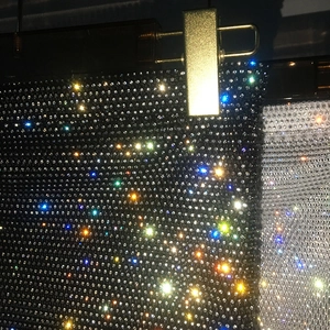 Close-up of sparkling rhinestones on black and silver mesh mini skirt fabric detail