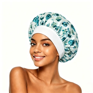 Close-up of floral satin sleep bonnet with wide elastic band worn by a smiling model