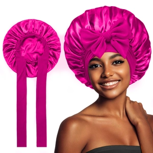 Detail of rose red satin sleep bonnet with a large bow and elastic band on model