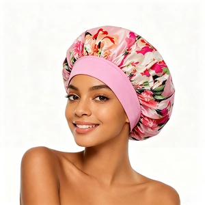 Gros plan d'un bonnet de nuit en satin rose fleuri avec un large bandeau élastique doux