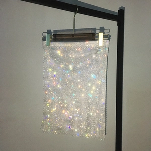 Detailed close-up of sparkling colorful rhinestones on a sexy fishnet mini skirt texture