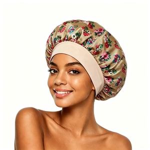 Close-up of floral satin sleep bonnet with wide elastic band and golden silk texture