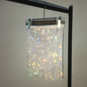 Detailed view of white mesh skirt with shimmering colorful rhinestones for party