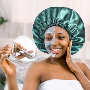 Detail of dark green satin sleep bonnet with elastic band for curly hair protection