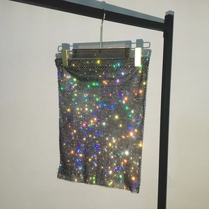 Detailed view of black fishnet mini skirt with colorful sparkling rhinestones on hanger