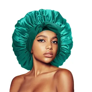 Emerald green satin bonnet for hair care featuring a large decorative bow and silk finish