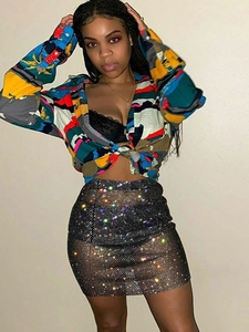 Women's sexy rhinestone fishnet mini skirt paired with a colorful print shirt