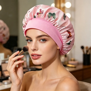 Detail of pink butterfly print satin sleep cap with wide elastic band and smooth texture