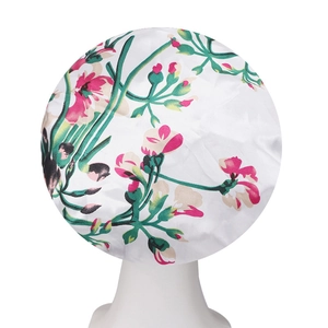 Detail of floral print satin sleep cap with pink flowers on white smooth fabric